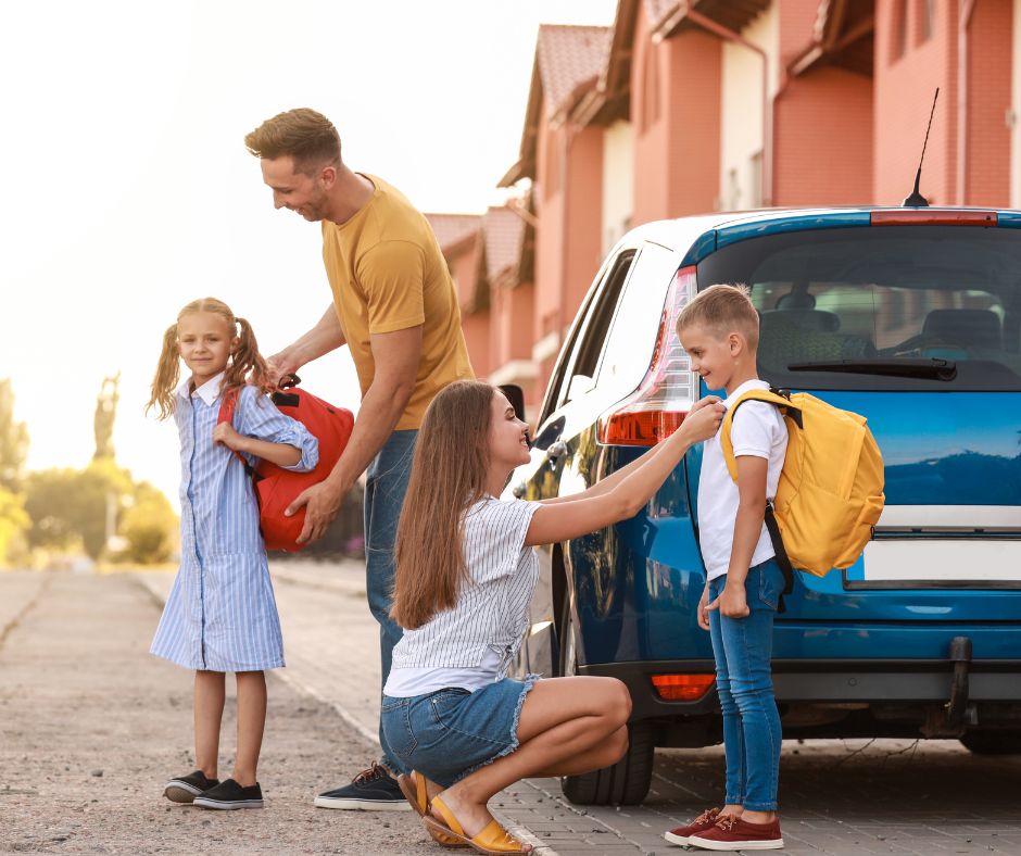 Back to school time with a family getting their kids ready to load up into the car.