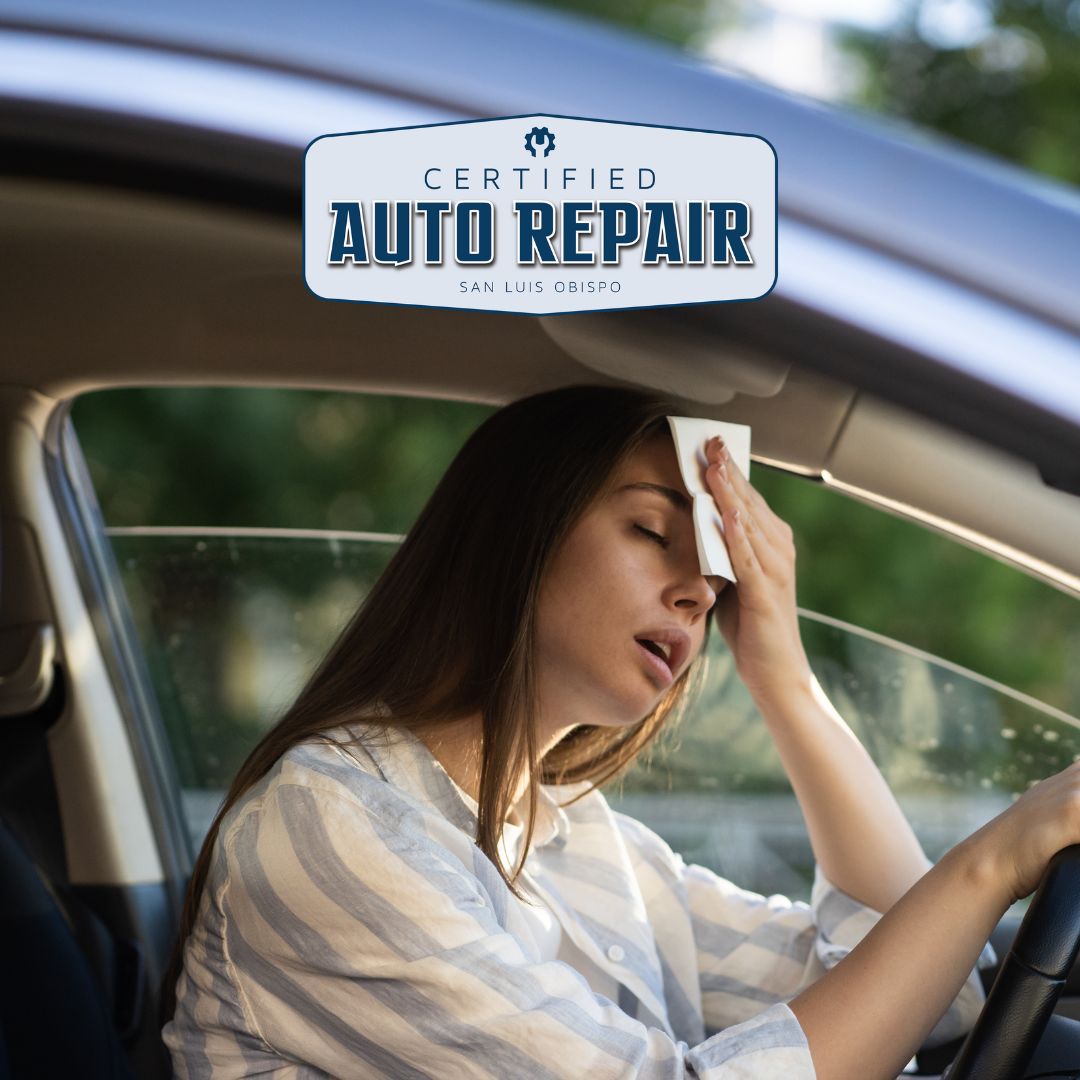 Woman in a hot car wiping sweat from her forehead.