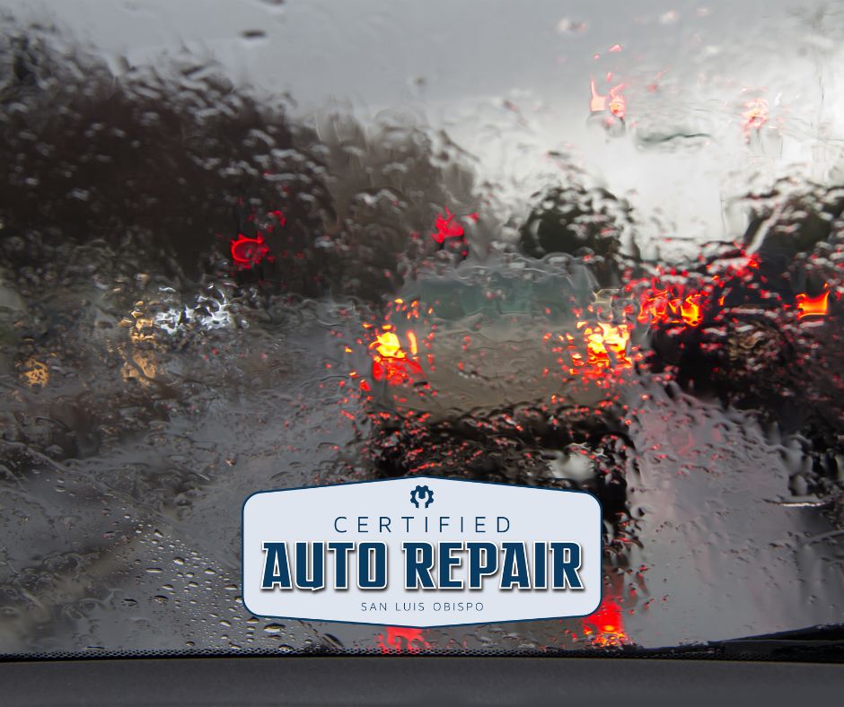 View from a car's front windshield of a rainy road.